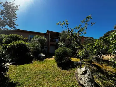 a house in the middle of a yard with trees at Apartment Pioppa for 4 in Porto-Vecchio