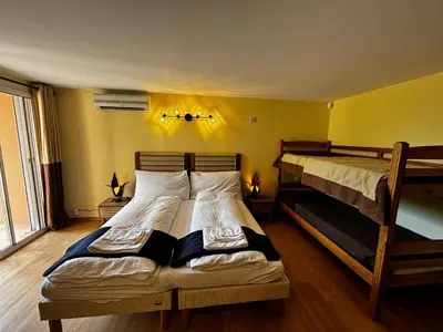 two beds in a room with yellow walls at Apartment Pioppa for 4 in Porto-Vecchio
