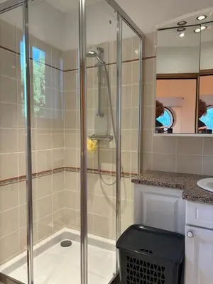 a shower stall in a bathroom with a woman in a mirror at Apartment Pioppa for 4 in Porto-Vecchio