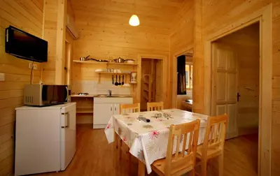 a dining room with a table and a kitchen at Camping U STABIACCIU in Porto-Vecchio