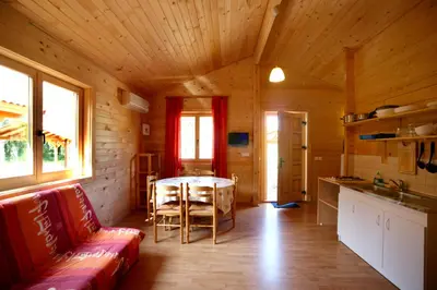 a room with a couch and a table in a cabin at Camping U STABIACCIU in Porto-Vecchio