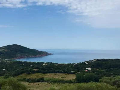 a view of a body of water from a hill at Les Hauts de Torraccia in Cargèse