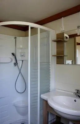 a white bathroom with a shower and a sink at Les Hauts de Torraccia in Cargèse