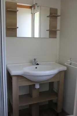 a bathroom with a white sink and a mirror at Les Hauts de Torraccia in Cargèse