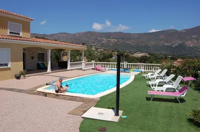 a man and a dog sitting next to a swimming pool at Perula di Machja in Alata