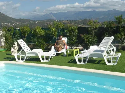 a woman sitting in a chair next to a pool at Perula di Machja in Alata
