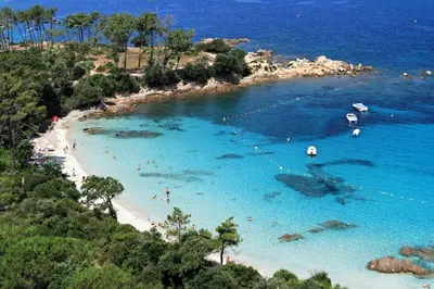 a beach with people swimming in the blue water at Perula di Machja in Alata