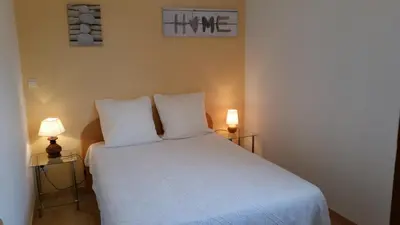 a bedroom with a white bed with two lamps at Maison Alba Rossa 56 in Serra-di-Ferro