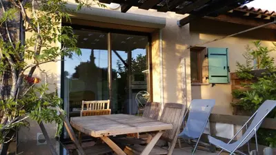 a wooden table and chairs on a patio at Maison Alba Rossa 56 in Serra-di-Ferro