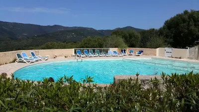 a large swimming pool with blue chairs at Maison Alba Rossa 56 in Serra-di-Ferro