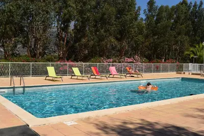 a couple of people are in a swimming pool at Camping Paradella in Calenzana