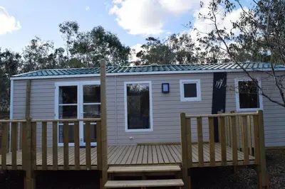 a tiny house with a wooden deck at Camping Paradella in Calenzana