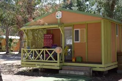 a green and orange house with a porch at Camping Paradella in Calenzana