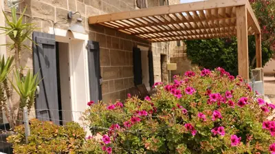 a building with flowers in front of a door at Casa Susini in Pianottoli-Caldarello