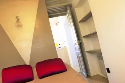 a red stool sitting in a room with a doorway at Casa Susini in Pianottoli-Caldarello