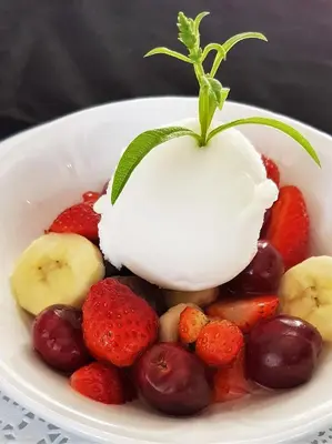 a bowl of fruit with strawberries bananas and cherries at Maison d'Hôtes Zella in Bains de Guitera