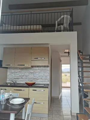 a loft bed in a kitchen with a dining table at Terres de France - Les Hauts du Maquis in Linguizzetta
