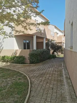 a brick walkway in front of a building at Terres de France - Les Hauts du Maquis in Linguizzetta