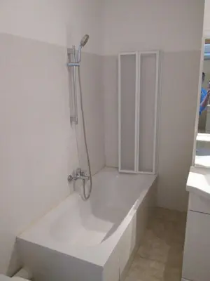 a white bath tub with a shower in a bathroom at Terres de France - Les Hauts du Maquis in Linguizzetta