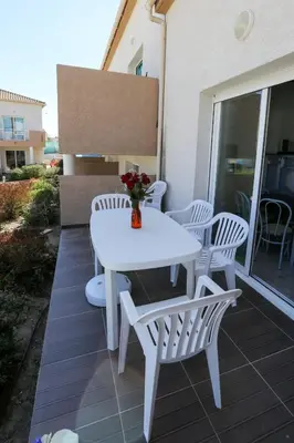 a white table and chairs on a patio at Terres de France - Les Hauts du Maquis in Linguizzetta