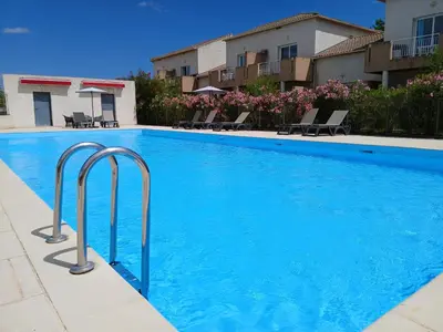 a large blue swimming pool in a hotel at Terres de France - Les Hauts du Maquis in Linguizzetta