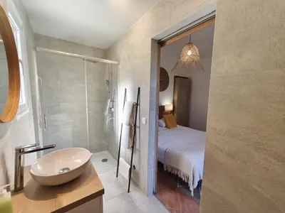 a bathroom with a bed and a sink and a shower at Chambres Isula Bella in Figari