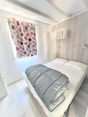 a small bedroom with a bed with a window at CAMPING LES ILOTS D'OR in Porto-Vecchio