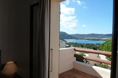a room with a balcony with a view of a lake at Bellavistaloc' in Porto-Vecchio
