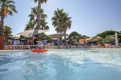 a little girl in a raft in a pool at a resort at Belambra Clubs Borgo - Pineto in Borgo