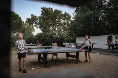 a group of people standing around a ping pong table at Belambra Clubs Borgo - Pineto in Borgo
