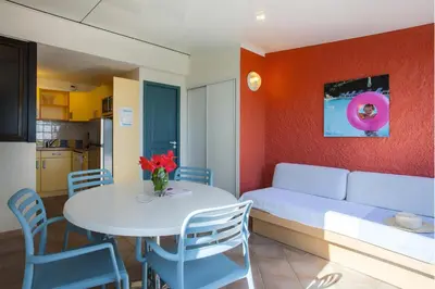 a room with a table and a bed and a table and chairs at Belambra Clubs Borgo - Pineto in Borgo