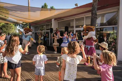 a group of children standing on a deck with mascots at Belambra Clubs Borgo - Pineto in Borgo