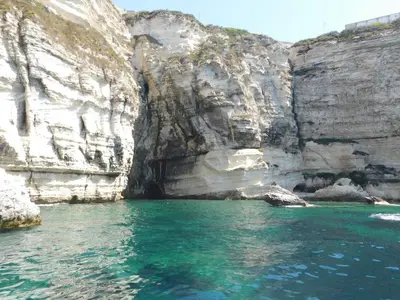 a body of water next to a rocky cliff at Le Chalet de Valentine & Laurent in Olmiccia