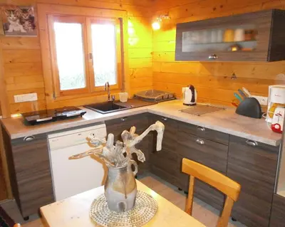 a kitchen with a vase sitting on a table at Le Chalet de Valentine & Laurent in Olmiccia