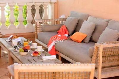a living room with a couch and a table with food at Hôtel Les Mouettes - Teritoria in Ajaccio