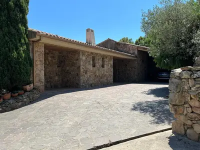 a house with a stone driveway with a garage at Maison En Pierre Corse Vue Mer in Sari Solenzara