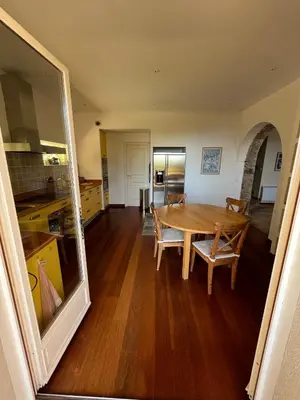 a kitchen and dining room with a wooden table at Maison En Pierre Corse Vue Mer in Sari Solenzara