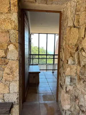 a stone wall with a bench in a room with a window at Maison En Pierre Corse Vue Mer in Sari Solenzara