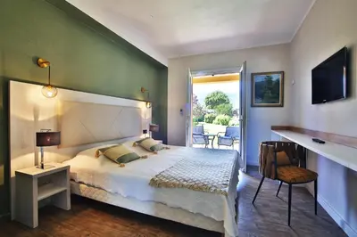 a bedroom with a large bed and a balcony at Hotel du Pont de l'Oso in Cala Rossa