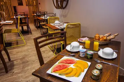 a wooden table with a plate of fruit on it at Hotel du Pont de l'Oso in Cala Rossa