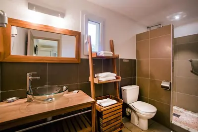 a bathroom with a sink and a toilet and a mirror at Hotel du Pont de l'Oso in Cala Rossa