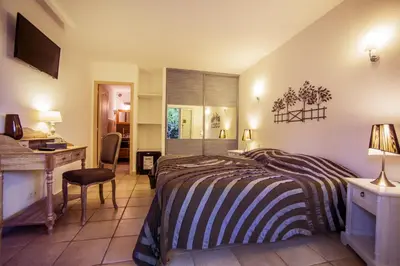 a bedroom with a bed and a desk and a desk at Hotel du Pont de l'Oso in Cala Rossa