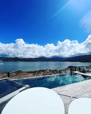 a swimming pool with a view of the water at Hôtel Castel d'Orcino in Calcatoggio