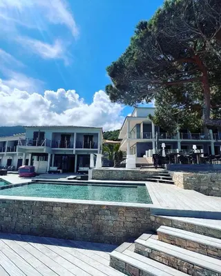 a resort with a swimming pool and a building at Hôtel Castel d'Orcino in Calcatoggio