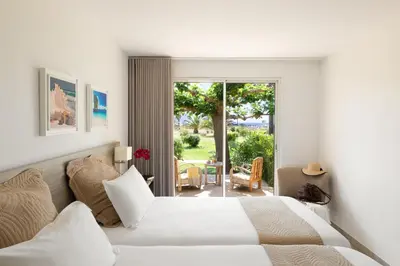 a bedroom with two white beds and a patio at Hôtel-Restaurant Marina Di Lava - Grand Ajaccio in Appietto