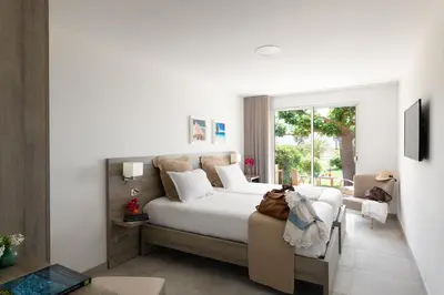 a bedroom with a white bed and a window at Hôtel-Restaurant Marina Di Lava - Grand Ajaccio in Appietto