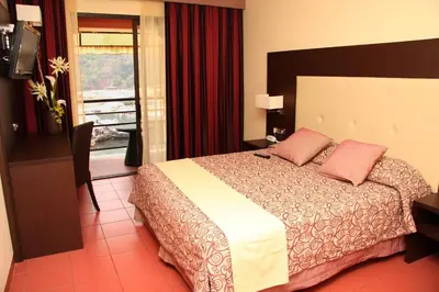 a hotel room with a bed and a window at Hôtel & Restaurant Le Belvédère in Porto Ota