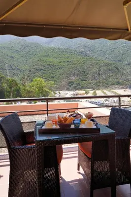 a table with a tray of food on a balcony at Hôtel & Restaurant Le Belvédère in Porto Ota