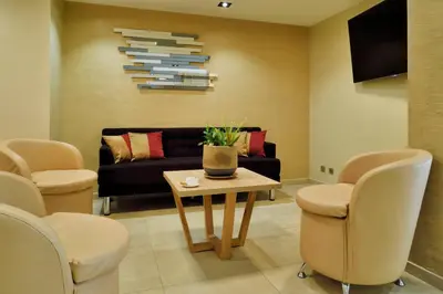 a waiting room with a couch and a table and chairs at Hôtel & Restaurant Le Belvédère in Porto Ota