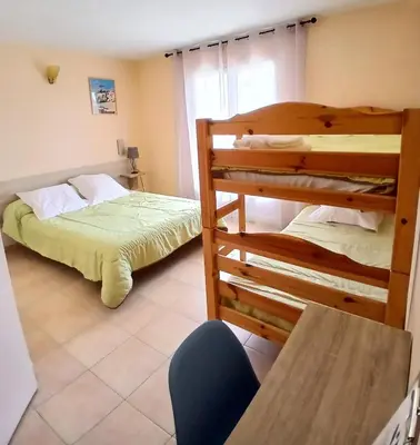 a room with two bunk beds and a table at Scopa Rossa in Evisa